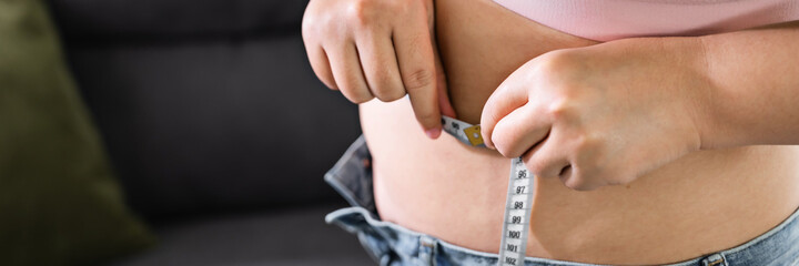 Chubby obese woman &nbsp;check out body fat with measuring tape health care diet lifestyle concept