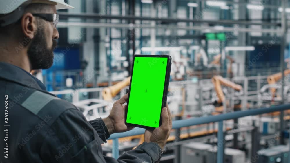 Aufkleber Car Factory Engineer in Work Uniform Using Tablet Computer with Green Screen Mockup Display. Augmented Reality Software at Automotive Industrial Manufacturing Facility Working on Vehicle Production.