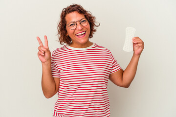 Middle age woman holding a compress isolated on white background joyful and carefree showing a...