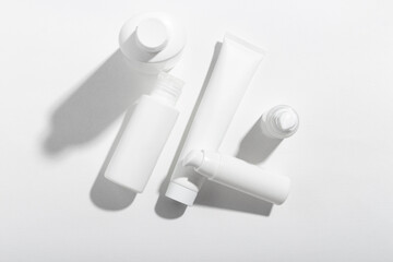 Fototapeta premium A set of cosmetic products in white tubes with empty space for labeling. Cosmetics for face and body skin care. Moisturizing cream, purifying mask.
