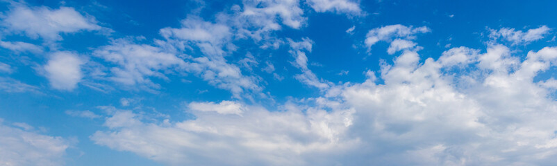 Naklejka na ściany i meble Luxurious white clouds in the blue sky on a sunny day