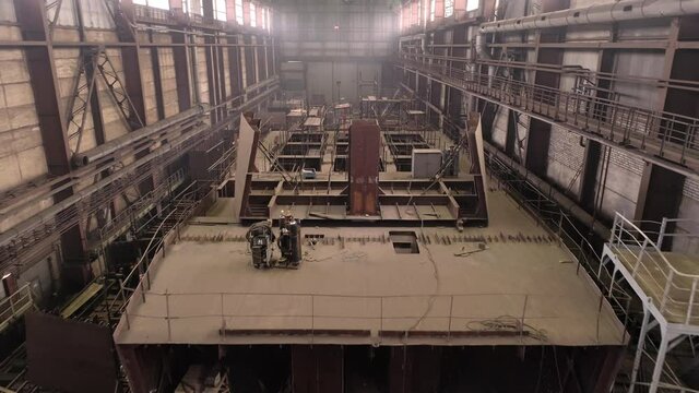 Huge old crab vessel with holes in upper deck and different equipment in spacious dry dock of industrial complex