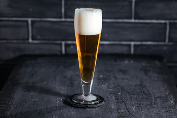 Glass of beer on a dark background with different snacks