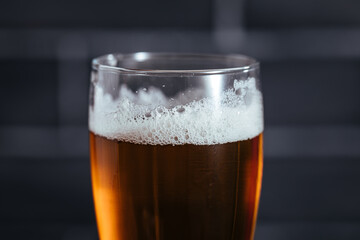Close up of top of beer glass with foam