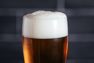 Close up of top of beer glass with foam
