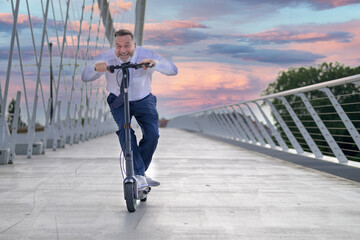 Happy sporty senior man riding an electric scooter © michaelheim
