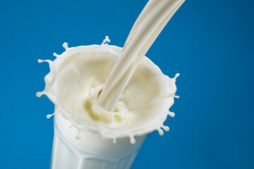 Pouring milk splash in glass, top view