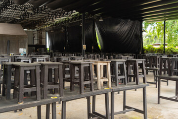 Wooden chairs stacked on tables. Local restaurant temporarily closed during lockdown COVID-19 or...