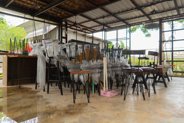 Wooden chairs stacked on tables. Local restaurant temporarily closed during lockdown COVID-19 or...