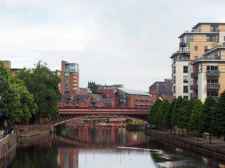 Naklejka premium view along the river aire in leeds with crown point bridge surrounded by modern apartment buildings