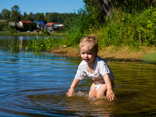 little girl splashing in the water near the shore