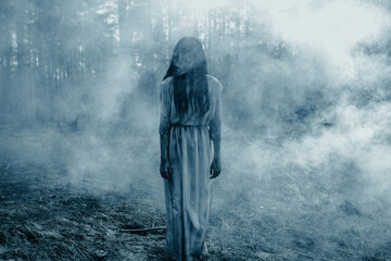 Girl in image of scary zombie walks in dark forest among smoke. © Stanislav