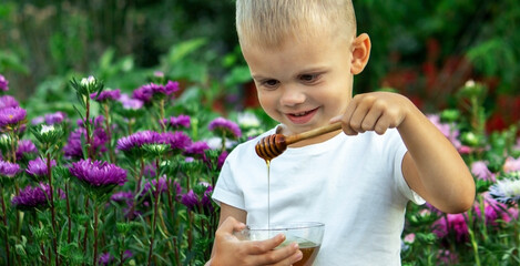 child eats honey in the garden.