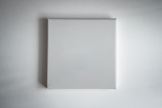 White square clean canvas for photography or drawing lies on white paper (969)