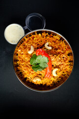 Top view of biryani or biriyani with various vegetables and fruits on pulau