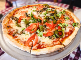 Large Pizza Primavera Topped with Fresh Garden Vegetables: A large pizza topped with tomatoes,...
