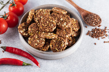 Energy cookies or crispbread (from sesame seeds, flax seeds and other cereals) with tomatoes and chili