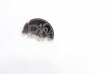 metal ruble in the snow, part of the ruble fell into a snowdrift