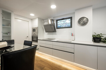contemporary kitchen with gray cabinets and stainless steel appliances in a vacation rental apartment