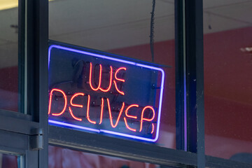 red blue neon sign says we deliver