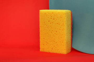 yellow sponge and gray plate, red background