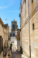 Fototapeta na wymiar Medieval Street in the centre of the town of Oria, in the South of Italy and Belltower on the Background