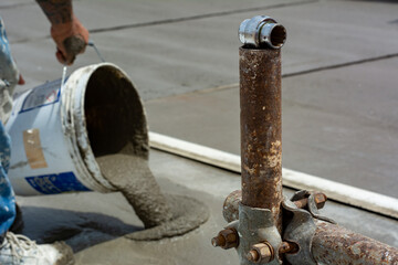 Worker Spreading Building Screed on a Floor of a House during Energy Redevelopment Work