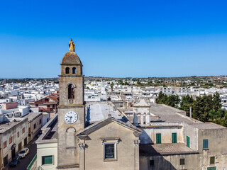 Fototapeta na wymiar Close Up on the Madonna Golden Statue on the Belltower of the Santuario of Maria Addolorata shooted by Drone in the Town of Taviano