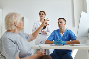 Fototapeta premium an elderly woman at a doctor's appointment with a nurse in a hospital health