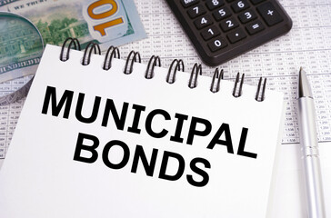On the table there is money, a calculator and a notebook with the inscription - MUNICIPAL BONDS