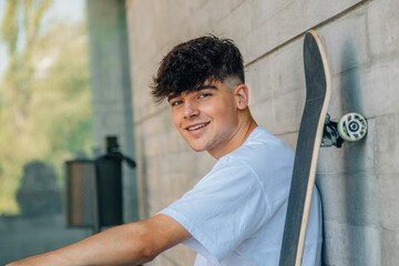 portrait of young teenage girl with fashionable hairstyle looking at camera smiling with skateboard...