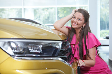 Fototapeta na wymiar Charming plus size woman smiling to camera posing with her new automobile, copy space
