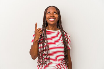 Young african american woman isolated on white background indicates with both fore fingers up...