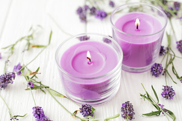 Obraz na płótnie Canvas aromatherapy lavender candles and flowers on white wooden background