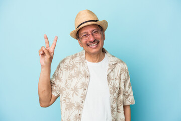 Senior indian man wearing summer clothes isolated on blue background Senior indian woman wearing a african costume isolated on white background joyful and carefree showing a peace symbol with fingers.