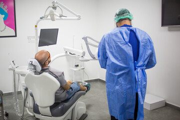 Caucasian male is waiting for a teeth check up in a dental chair in a dentist office