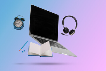 Creative minimal composition made with a laptop, headphones, school supplies and alarm clock ...