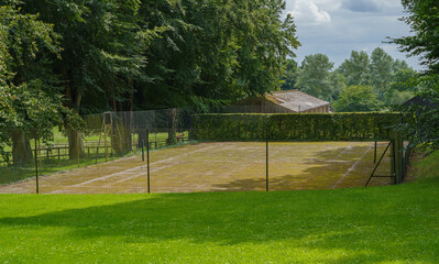 The neglected Manor Farm House private tennis court, ashphalt covered in lichen