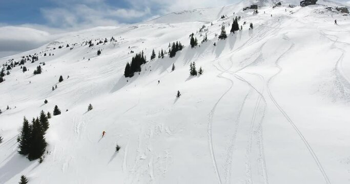 Aerial view of freeride big mountain skiing (backcountry skiing) in the fresh powder snow, extreme adventure skiing from the mountain peak