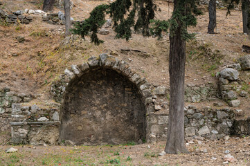 Ancient ruins on the slope of Acropolis hill. Stone arch in mountain.