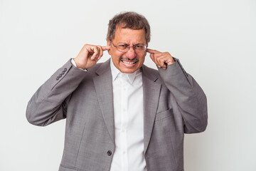 Middle aged indian business man isolated on white background covering ears with hands.