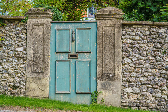 a blue painted aged wooden door leading to the garden of the Manor Farm, Huish on the South facing edge of the Marlborough Downs, adjacent to Pewsey Vale, Wiltshire