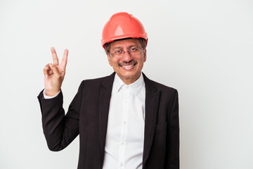 Middle aged indian architect man isolated on white background joyful and carefree showing a peace symbol with fingers.