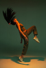 Dancing athletic mixed race girl performing expressive fiery hip hop or ethnic modern dance in...
