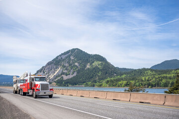 Powerful big rig towing semi truck tow another broken semi truck transporting it to repair shop...