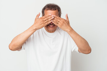 Middle aged indian man isolated on white background afraid covering eyes with hands.