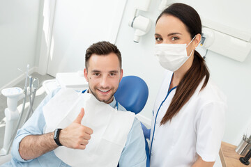 Dentist and patient showing thumb up.