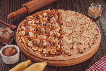 Brazilian sweet pizza half banana, dulce de leche and cinnamon, and half pizza peanut candy. (Pizza meio a meio)