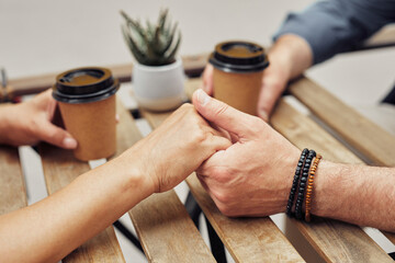 Close up of romantic senior couple holding hands in outdoor cafe during date, copy space