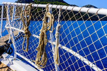 Ropes hanging on railings at the yacht bow